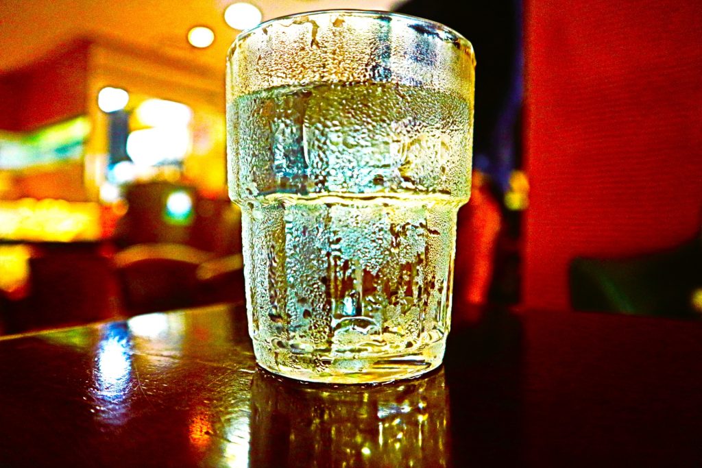 alt="真夏に冷たいコップを置くと、表面に水滴が付くさまを水蒸気の冷却に見立てたイメージ写真"